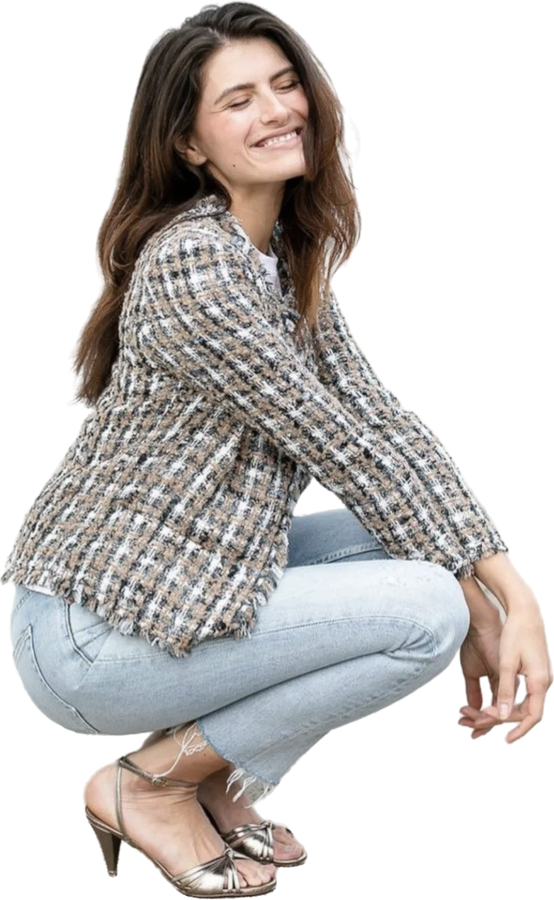 Een vrouw zit op haar hurken. Ze kijkt blij en tevreden.