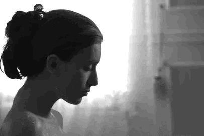 Een man streelt een jonge vrouw over haar gezicht, en dwingt haar om hem in de ogen te kijken.
