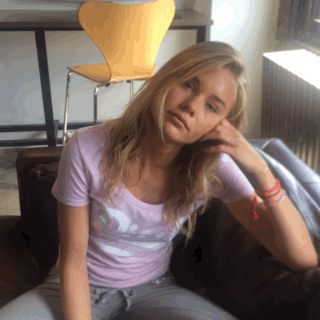 Een vrouw zit op een bank en maakt een zeer vermoeide indruk.