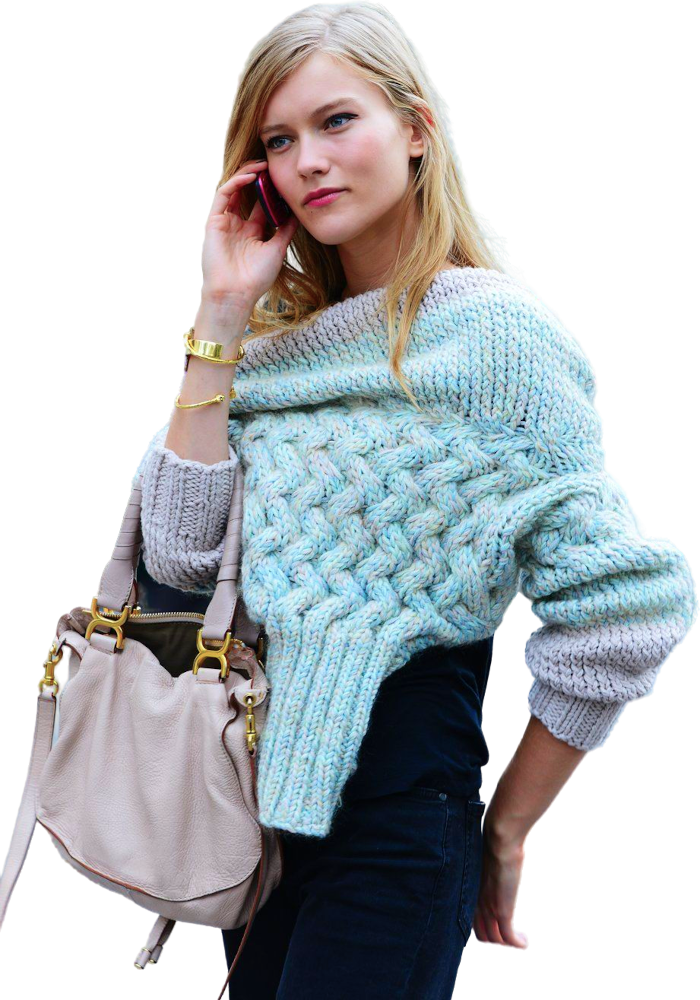 Een vrouw, gekleed in een zwarte broek, met een trui over haar schouders. Ze draagt een handtas en is aan het bellen met een smartphone, terwijl ze haar andere hand voorzichtig aan haar billen voelt.
